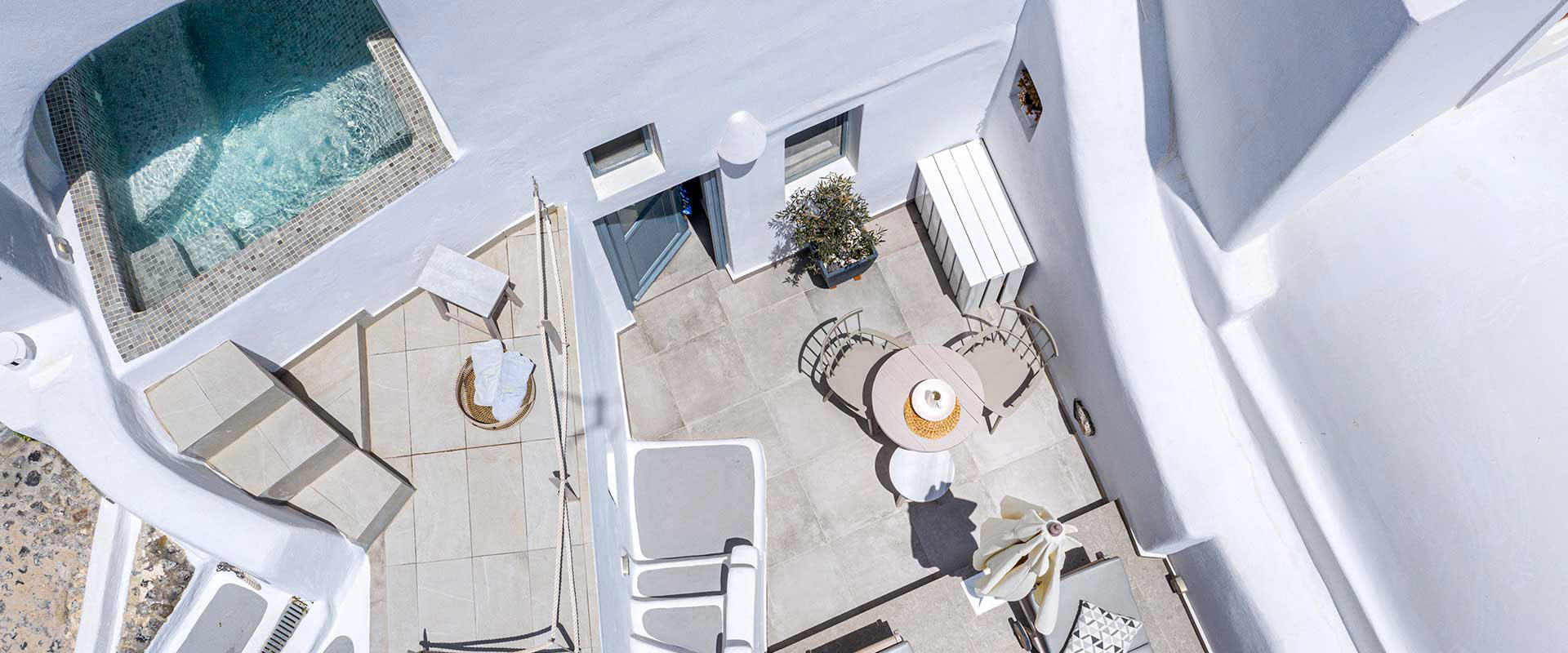 Quiet Santorini terrace with pool and caldera backdrop